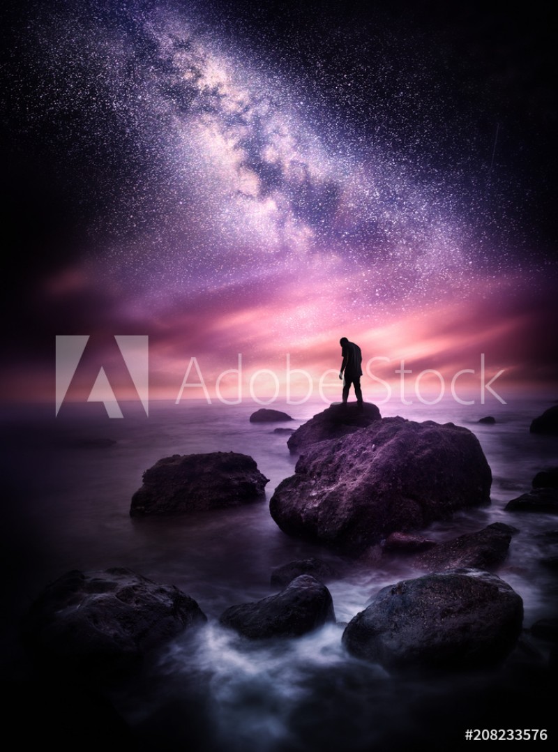 Afbeeldingen van Night time Sea landscape with the Milky Way A man stands on a rocky shore line with the stars above him Photo composite